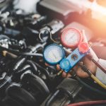 Hand of young mechanic with Gauges Set, Check the pressure and leak. Servicing car air conditioner